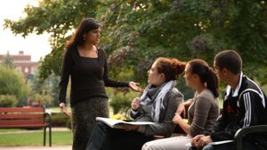 Professor talking to students outside.
