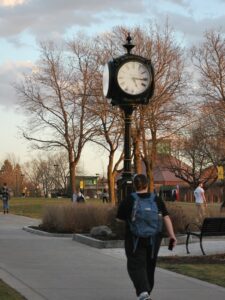 Students passing the clock tower at dusk