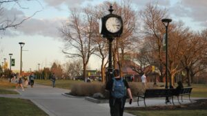 Students passing the clock tower at dusk