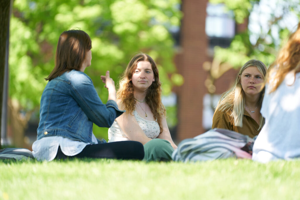 Students sitting in the quad on a sunny day