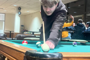 Student playing pool in the Corcoran Lounge