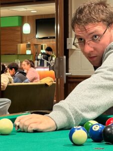 Male student lining up pool shot