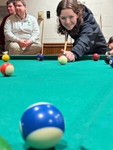 Female stufent lining up her pool shot
